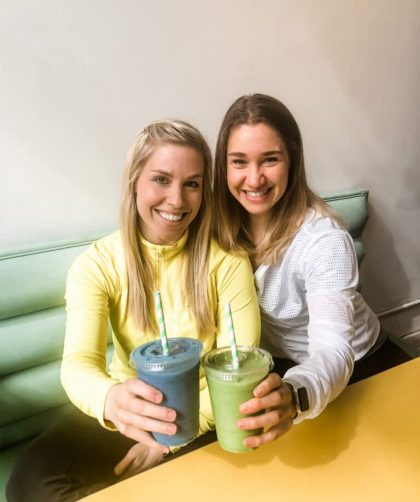Two dietitians holding cups and showing how to make your own protein shake.